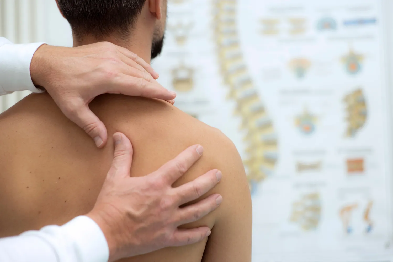 Chiropractor assessing shoulder joint pain